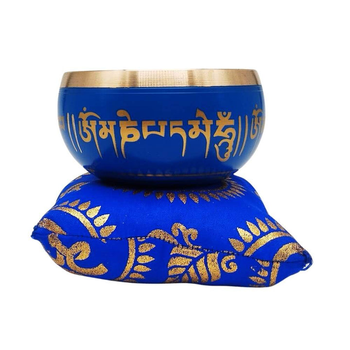 Buddhist singing bowl on blue cushion, front view