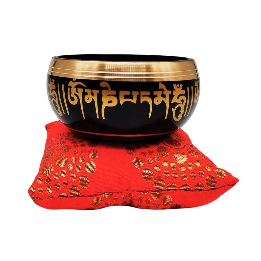 Buddhist singing bowl on red cushion, front view